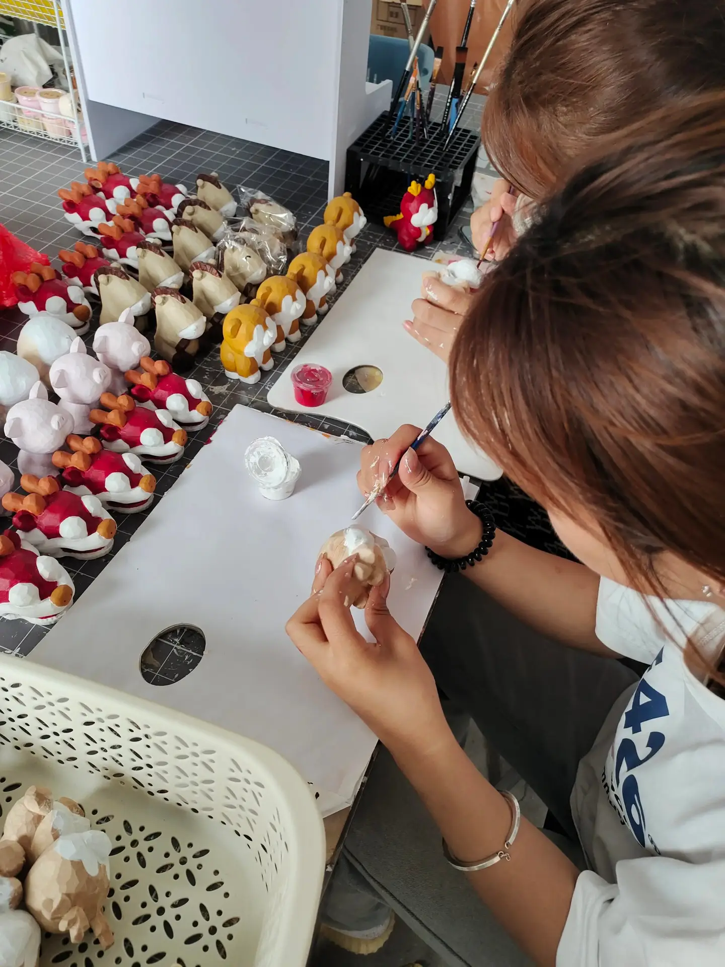A female worker is carving a wooden sculpture.